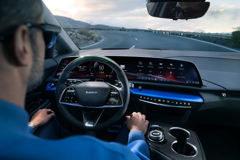 Front View of the 2026 OPTIQ-V Driving Through the Dusk Utilizing its Headlights | Parker Cadillac in Little Rock AR